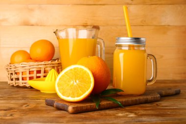 Mason kavanozu ve ahşap arka planda taze portakal suyu.