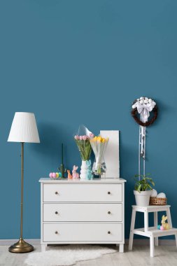 Paskalya için dekore edilmiş oturma odasının içinde tuvalet ve vazolar var.