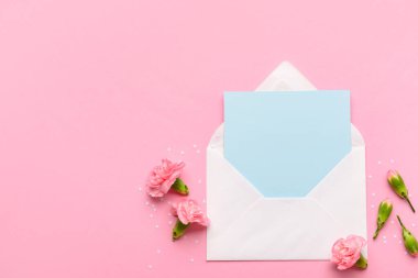 Zarflı güzel karanfiller ve pembe arka planda boş bir kart. Uluslararası Kadınlar Günü kutlamaları