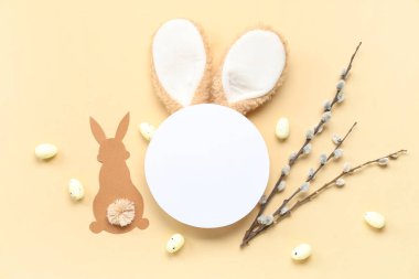 Tavşan kulaklı boş kart, Paskalya yumurtası ve bej arka planda söğüt dalları.