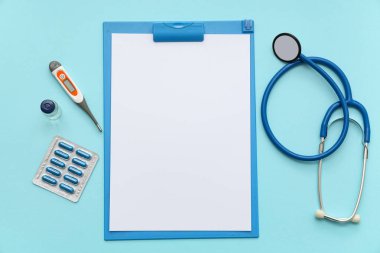 Blank clipboard with medical supplies on blue background. World Health Day