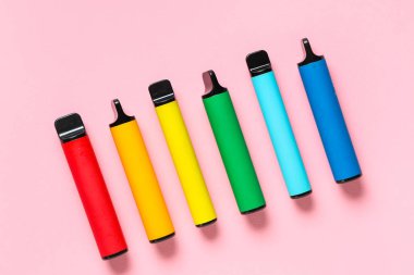 Pembe arka planda farklı elektronik sigaralar.