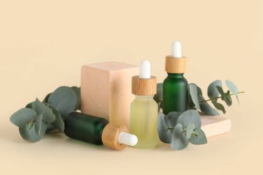 Gerekli yağ şişeleri, alçı tezgahları ve bej arka planda okaliptüs dalları