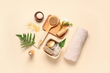Renkli arkaplanda spa aksesuarları, kozmetik ürünleri ve eğreltiotu yaprakları ile kompozisyon