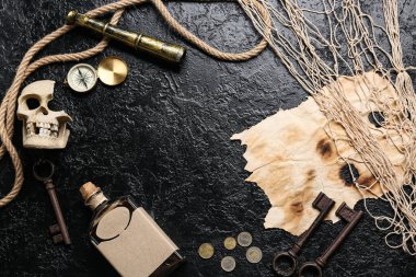 Kafatası, pusula, bozuk para, rom ve kağıttan yapılmış bir çerçeve. Korsan konsepti