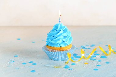 Tatlı doğum günü keki yanan mum ve açık mavi masada konfeti