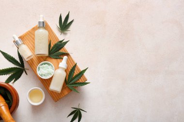 Deniz tuzu ve beyaz arka planda yapraklarla kenevir kozmetik yağı şişeleri