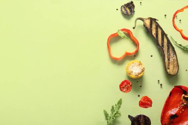 Yeşil arka planda lezzetli ızgara sebzeler uçuşuyor.