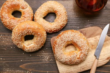 Tahta arka planda susam tohumlu lezzetli simit kesme tahtası