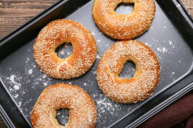 Ahşap zemin üzerinde susam tohumları olan lezzetli simitler pişirmek.