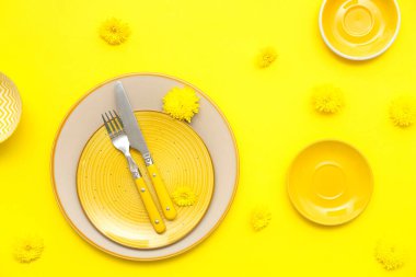 Sarı arka planda güzel karahindiba çiçekleri olan şık bir masa.