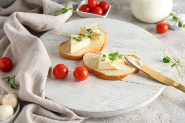 Lezzetli işlenmiş peynir üçgenleriyle beyaz ahşap ekmek dilimleri ve gri arka planda mikro yeşil