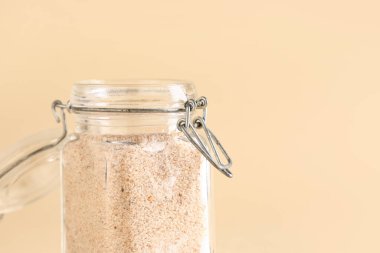 Bej arka planda psyllium kabuklu kavanoz.