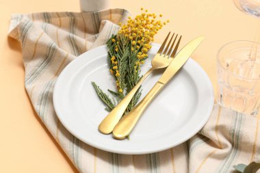 Turuncu arka planda mimoza çiçekleri olan güzel bir masa, yakın plan.