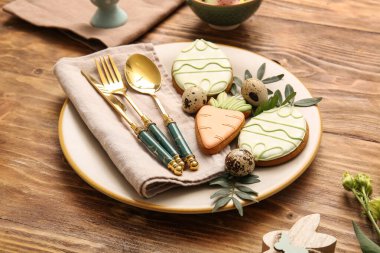 Tatlı kurabiyeler, bıldırcın yumurtaları ve ahşap arka planda yaprakları olan güzel bir masa. Paskalya kutlaması