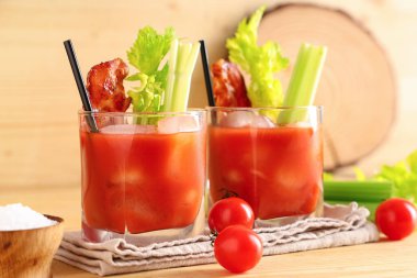 Domuz pastırması ve ahşap arka planda kereviz olan Bloody Mary kokteyli.