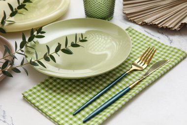 Beyaz arkaplanda okaliptüs dalları olan güzel masa ayarları, yakın plan