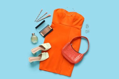 Mavi arka planda ayakkabılı, çantalı ve makyaj malzemeli balo elbisesi.