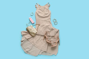 Mavi arka planda ayakkabılı, çantalı ve aksesuarlı balo elbisesi