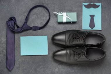 Boş tebrik kartı, kravat, ayakkabı ve koyu grunge arka planda hediye kutusu. Babalar günü kutlaması.
