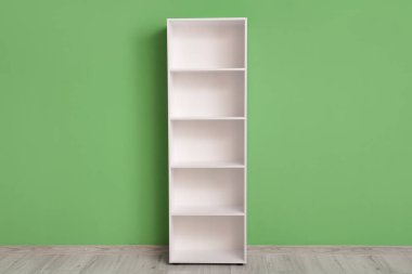 Yeşil duvarın yanında boş beyaz raf ünitesi