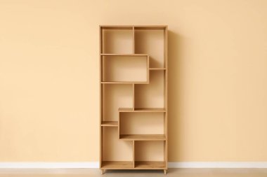 Bej duvarın yanında boş ahşap raf ünitesi