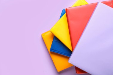 Leylak arkaplanı üzerine birçok renkli kitap