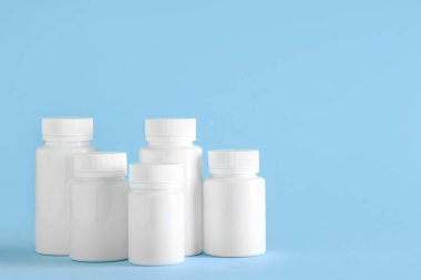 Açık mavi arka planda bir şişe diyet takviyesi