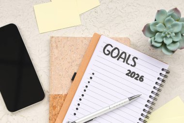 2026 gollü defter, cep telefonu ve beyaz grunge arkaplanı üzerine kağıt notlar