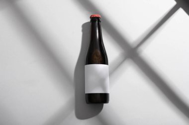 Gri arka planda bir şişe soğuk bira.