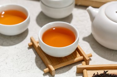 Beyaz arka planda bir fincan siyah çay ile ahşap tepsi, yakın plan.