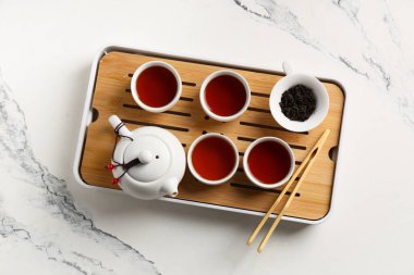 Çaydanlık tepsisi ve mermer arka planda siyah çay.