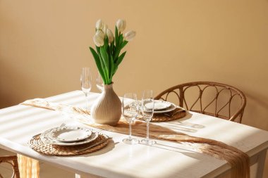 Kadınlar Günü için hazırlanmış yemek masası ve odada laleler.