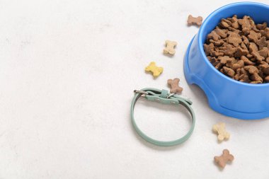 Tasma ve arka planda bir kase kuru yiyecek.