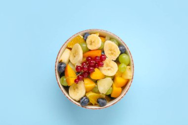 Mavi arka planda taze meyve salatası.
