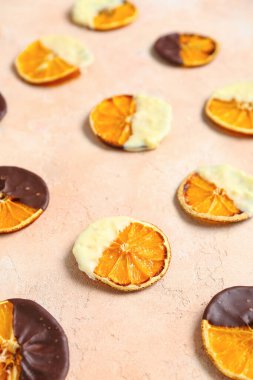 Bej arka planda çikolatalı kurutulmuş portakal dilimleri.