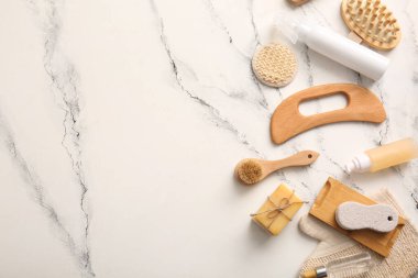 Ahşap guasha vücut masajı aracı ve mermer arka planda sabun çubukları ile kompozisyon