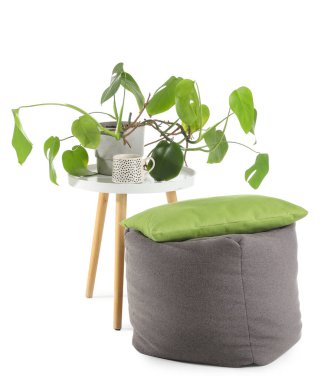 Çiçeklerle, bir bardak içecekle ve beyaz arka planda yastıkla dur.