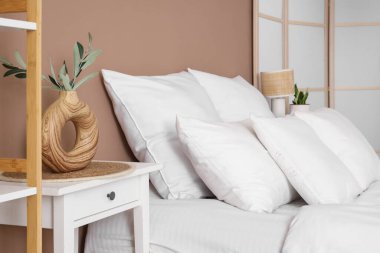 Yatak odasında bir sürü yastığı olan rahat bir yatak.