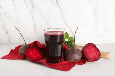 Beyaz arka planda fesleğenli ve sebzeli taze pancar suyu.