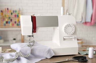 Atölyede kumaş ve terzi malzemeleri olan modern dikiş makinesi.