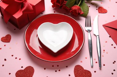Hediye kutusu, kalpler ve pembe arka planda kırmızı güller olan güzel bir masa. Sevgililer Günü kutlaması