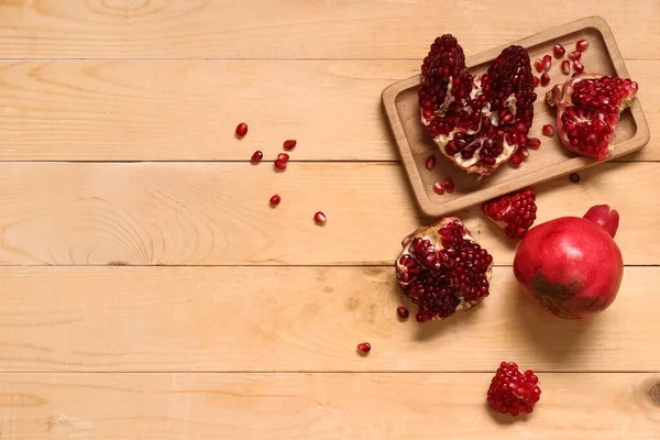 Kesilmiş taze nar tepsisi ve ahşap zemin üzerinde tohumlar