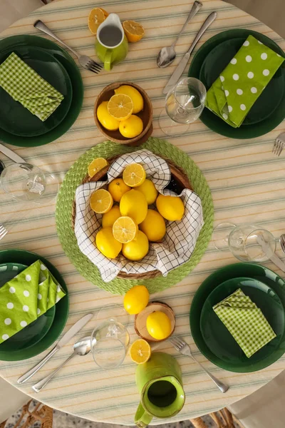 Yemek odasında bir sürü taze limonla dekore edilmiş şık masa seti.