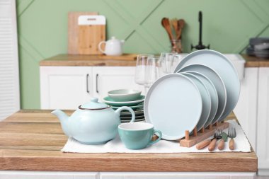 Mutfaktaki ahşap masada temiz mavi tabaklar.