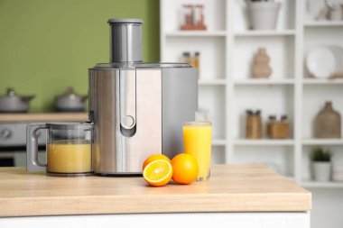 Mutfaktaki taze portakallı modern meyve sıkacağı.