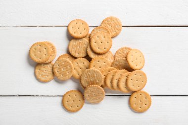 Beyaz ahşap arka planda dağınık lezzetli krakerler