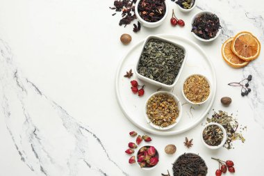 Mermer zemin üzerinde değişik çay çeşitleri içeren kompozisyon