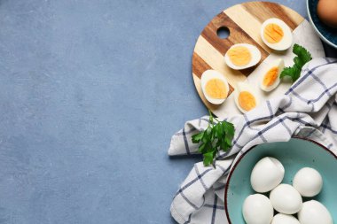 Mavi grunge arka planında haşlanmış yumurta ve kase.
