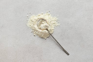 Grunge arka planında süt tozu olan kaşık